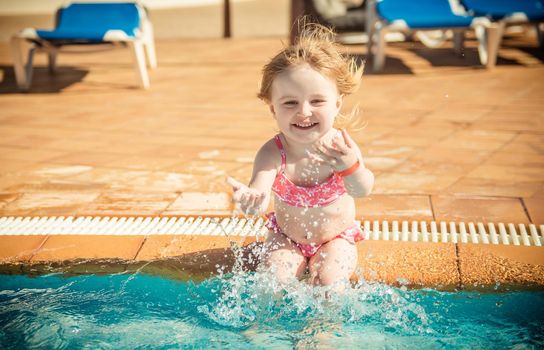 happy little girl playing in the pool