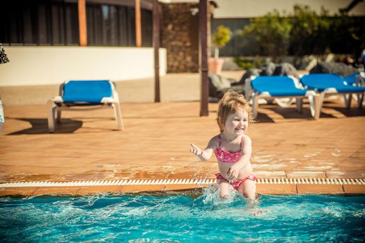 happy little girl playing in the pool