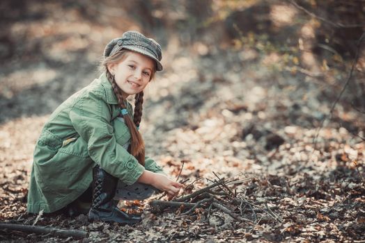 little girl making a bonfire, photo in vintage style