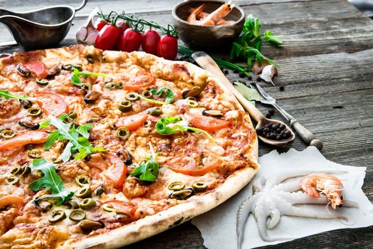 delicious pizza with seafood on wooden table