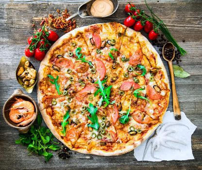 delicious pizza with seafood on wooden table