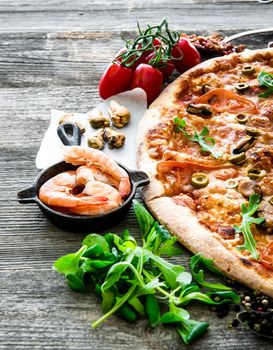 delicious pizza with seafood on wooden table