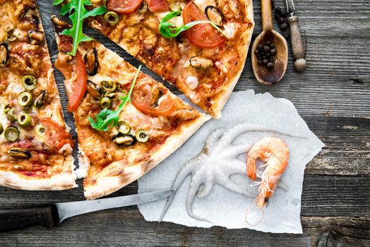 delicious pizza with seafood on wooden table
