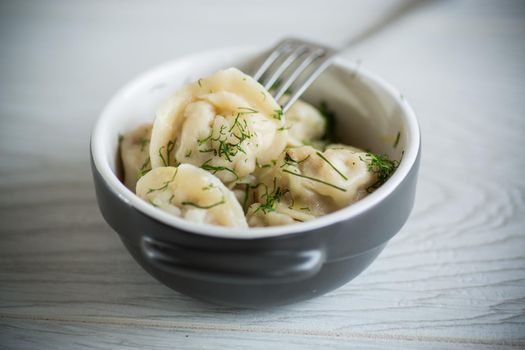 boiled dumplings with meat filling in a bowl on the table