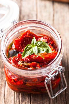 sun dried tomatoes in a glass jar with fresh basil