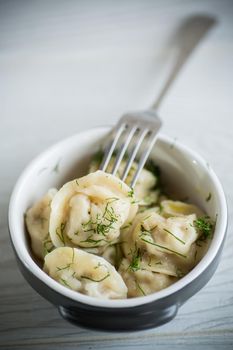 boiled dumplings with meat filling in a bowl on the table
