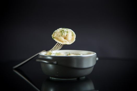 boiled dumplings with meat filling in a bowl on the table