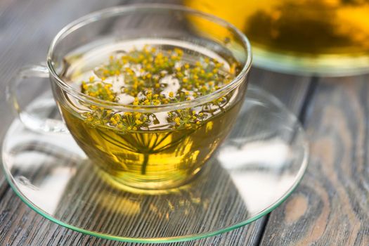 Herbal tea with dill in a glass cup outdoors