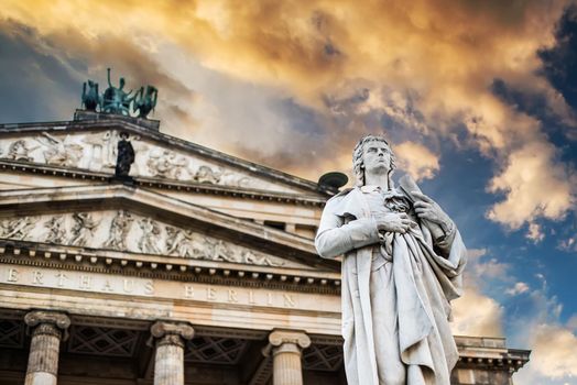 Beautiful squares in Berlin, the Gendarmenmarkt, marble statue of German poet Friedrich Schiller at sunset
