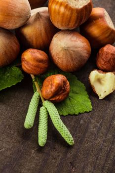 Hazelnuts with shell and green leaf on the wooden table