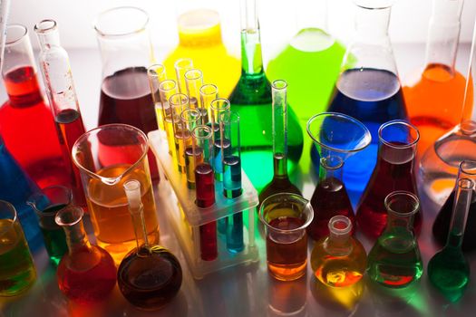 Laboratory glass with rainbow color liquids, chemistry still life