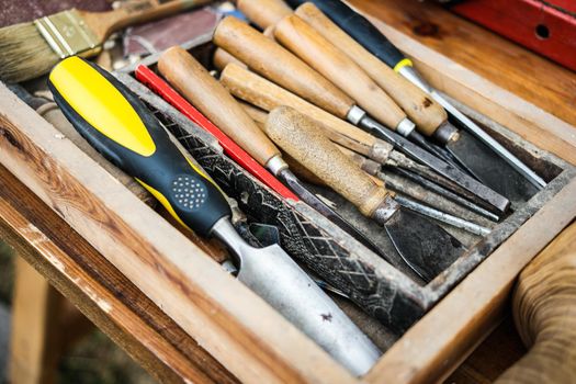 different tools and spatulas in wooden box