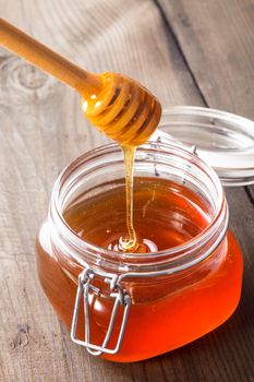 Honey drip in jar on the table