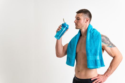 Male drink-water fitness is pumped with a towel on a white background isolated strong athlete health, drink sport male person, sporty hydration. Strength perfect, powerful one muscle