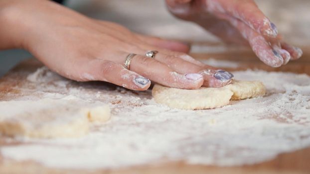 Woman's hands forming homemade pancakes from dough, close up