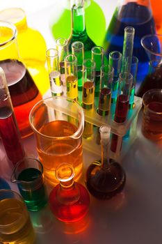 Laboratory glass with rainbow color liquids, chemistry still life