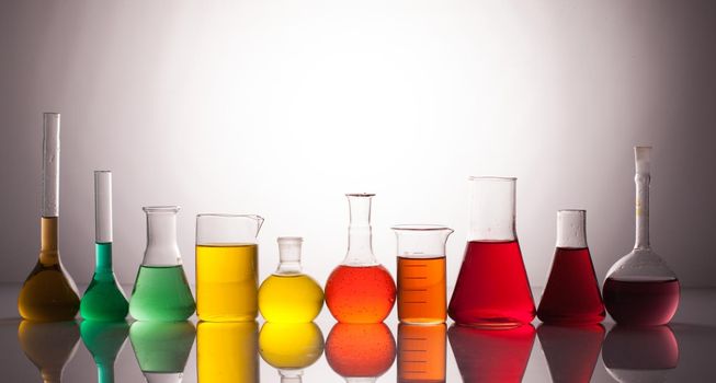 Laboratory glass with rainbow color liquids, chemistry still life