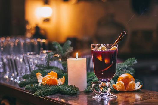 Red hot drink glintwein with spices, cinnamon, anise, fruits, brown sugar on an old wooden table. New Year and Christmas holidays concept. Mulled wine and glintwein