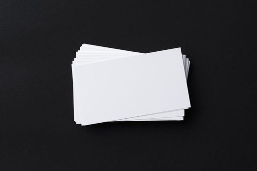 White blank business cards on dark black background, copy space