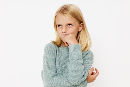happy child in a sweater, grimaces on a light background. High quality photo