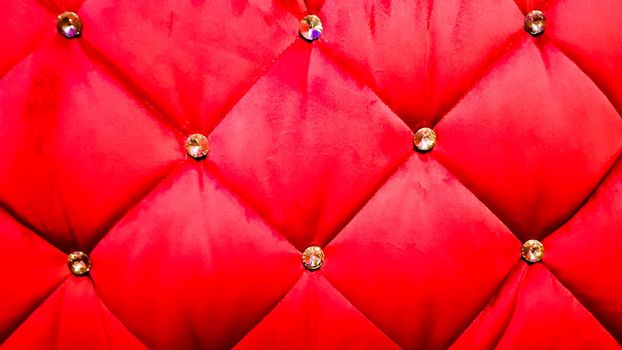 back of a red sofa. Red fabric texture background, Chesterfield style decoration with buttons, retro fabric. Retro diamond-shaped soft style fabric decorate with buttons. red velvet background.