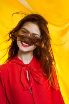 smiling woman in red dress posing yellow background. High quality photo