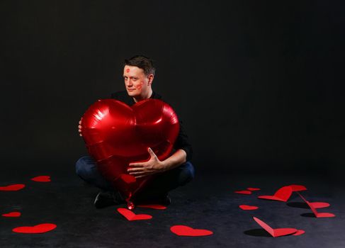 valentines heart red, an inflatable balloon in hands, romantic adventure. On a black background holiday greeting giving