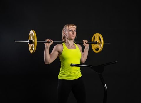Girl on a fitness trampoline on a black background in a yellow t-shirt woman, equipment body athlete lifestyle cardio, workout club. white aerobics, young muscle instructor enjoy