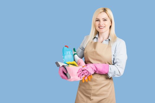 Young smiling cleaner woman. Isolated over blue background.