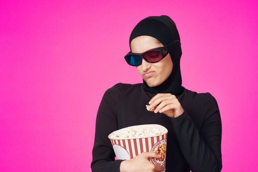 pretty woman in 3D glasses popcorn entertainment movies purple background. High quality photo