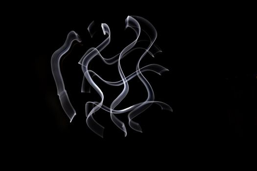 Unique, long exposure, white Led light painting photograph of abstract pattern on black background.