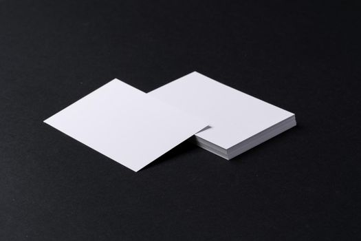 White blank business cards on dark black background, copy space