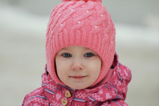 Portrait of a happy little girl having fun on snow, close up