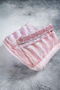 Raw whole rack of pork loin with ribs on kitchen table. White background. Top view.