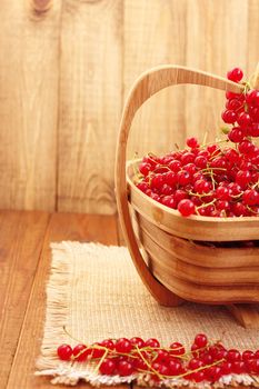 clusters of fresh ripe berries of red currant on the wooden vase