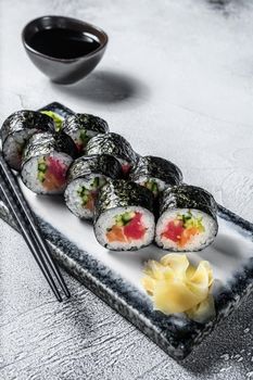 Maki Sushi rolls with salmon and tuna. Gray background. Top view.