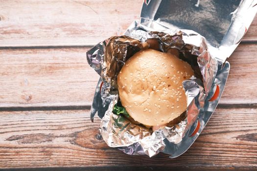 beef burger in a take away box on table .