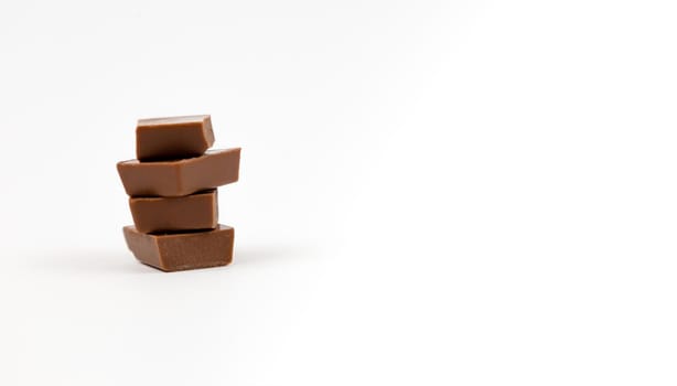 Macro photo of Chocolate bar. Broken pieces over white background.