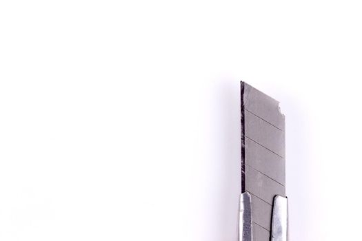 Tip of a stationery knife. Blade close up on a white background isolated.
