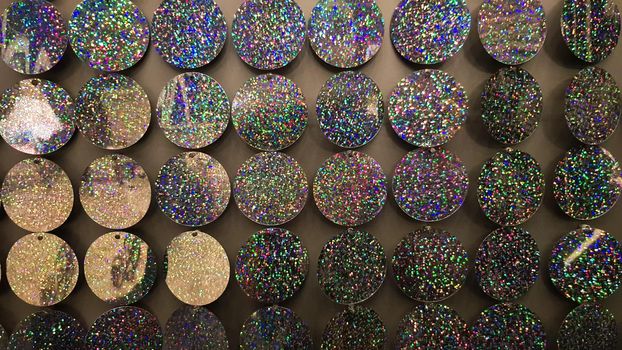 Macro close up of sparkles. Abstract background with gray sparkles. Texture scales of round spangles with color transition. Sequin background. Template for design. Festive background