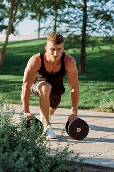 athletic man with dumbbells workout outdoors motivation. High quality photo