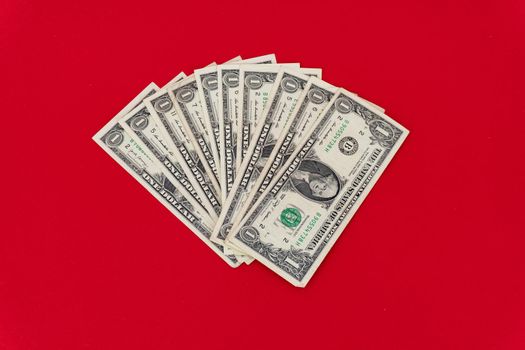 pile of ten one dollar bill on red background, minimal concept, isolated.