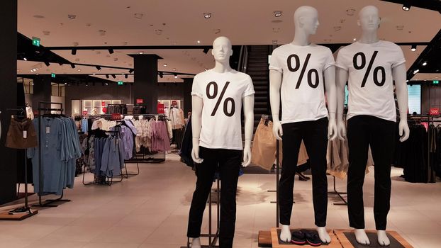 Mannequins wearing white T-shirts with a percent sale sign in a shopping mall Promotion, advertising, shopping and black friday concept. Ukraine, Kiev - September 1, 2020.