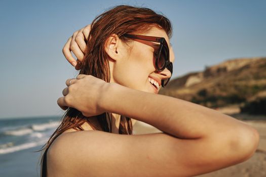 cheerful woman in sunglasses in a swimsuit on the beach sun island. High quality photo