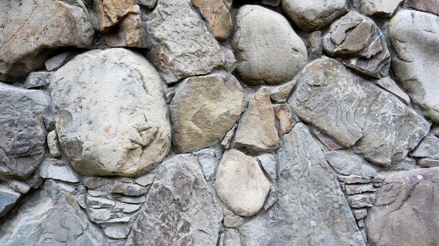 The texture of the stone wall. Old castle stone wall texture background. Stone wall as a background or texture. Part of a stone wall, for background or texture. pattern gray color modern style design.
