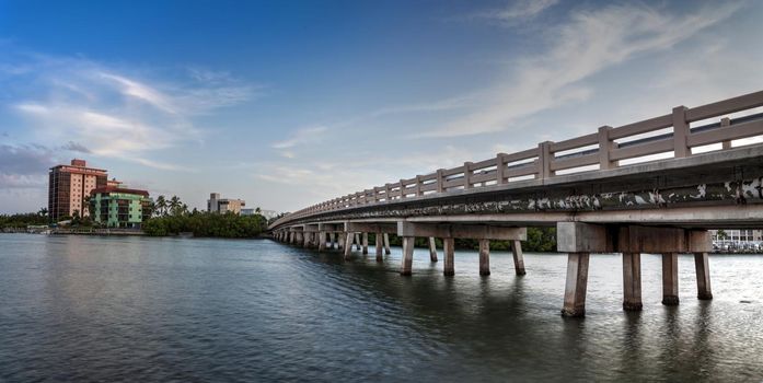 Blue sky over bridge over Hickory Pass leading to the ocean in Bonita Springs, Florida.