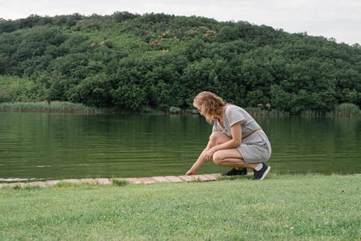 Nature and travel concept. woman sitting near the lake