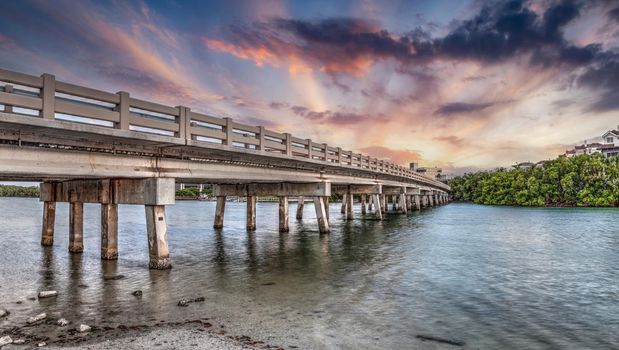 Sunset sky over bridge over Hickory Pass leading to the ocean in Bonita Springs, Florida.