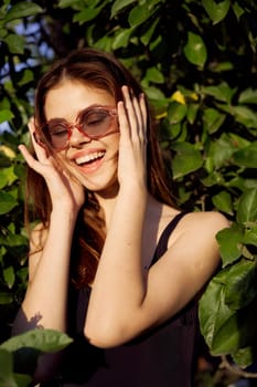 cheerful woman in black swimsuit green leaves nature posing. High quality photo