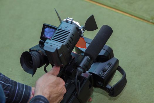 Covering an event with a video camera., Videographer takes video camera with free copy space for text., Video camera operator working with his equipment., close up of television operator with camera.